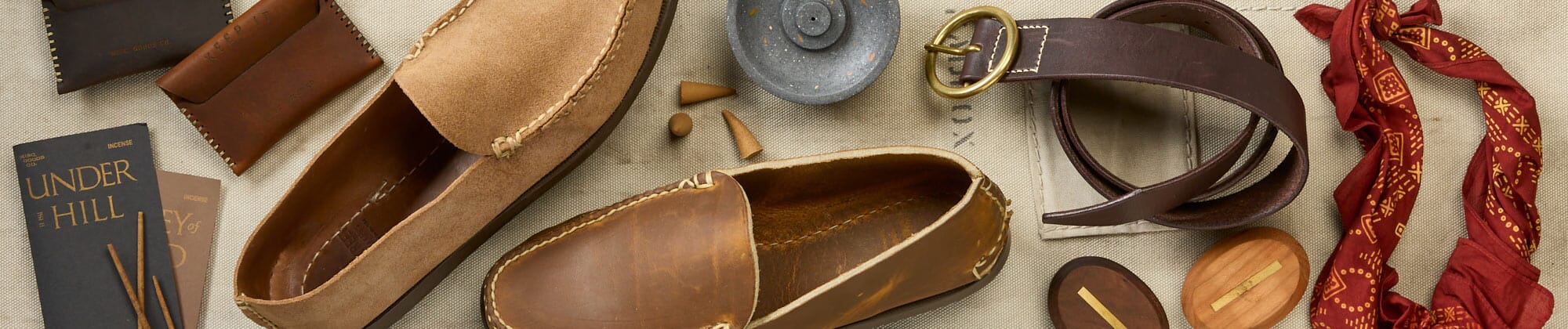 mens accessories; shoes, belts laying on a table