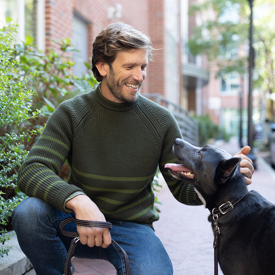 man petting a dog in a sweater by oobe brand
