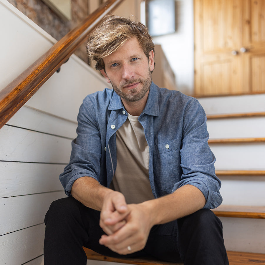 man sitting on stairs with a button down shirt on