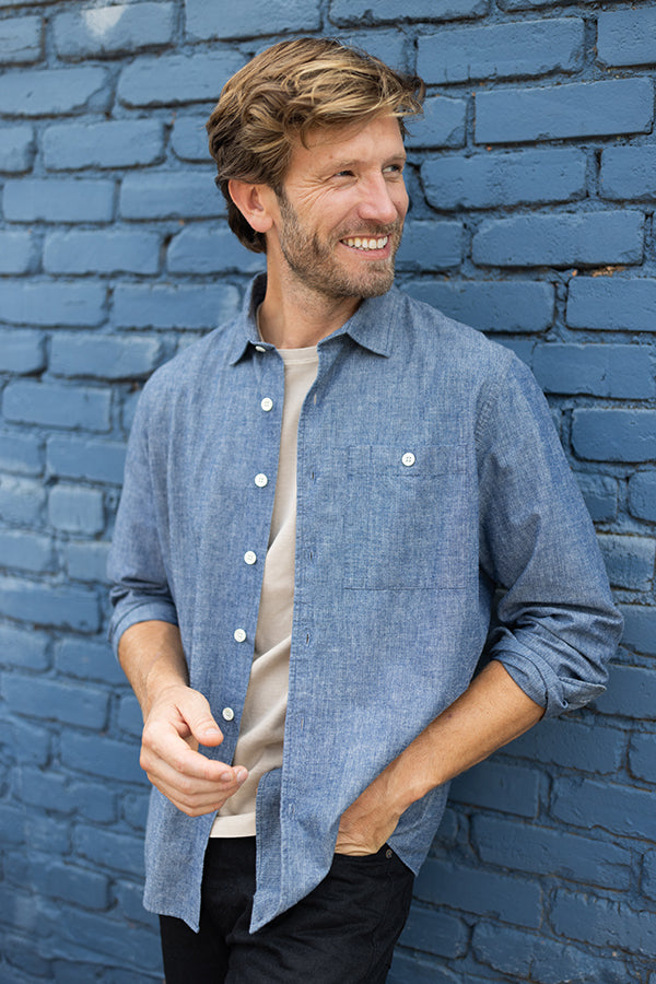 man standing against a wall in an oobe brand shirt