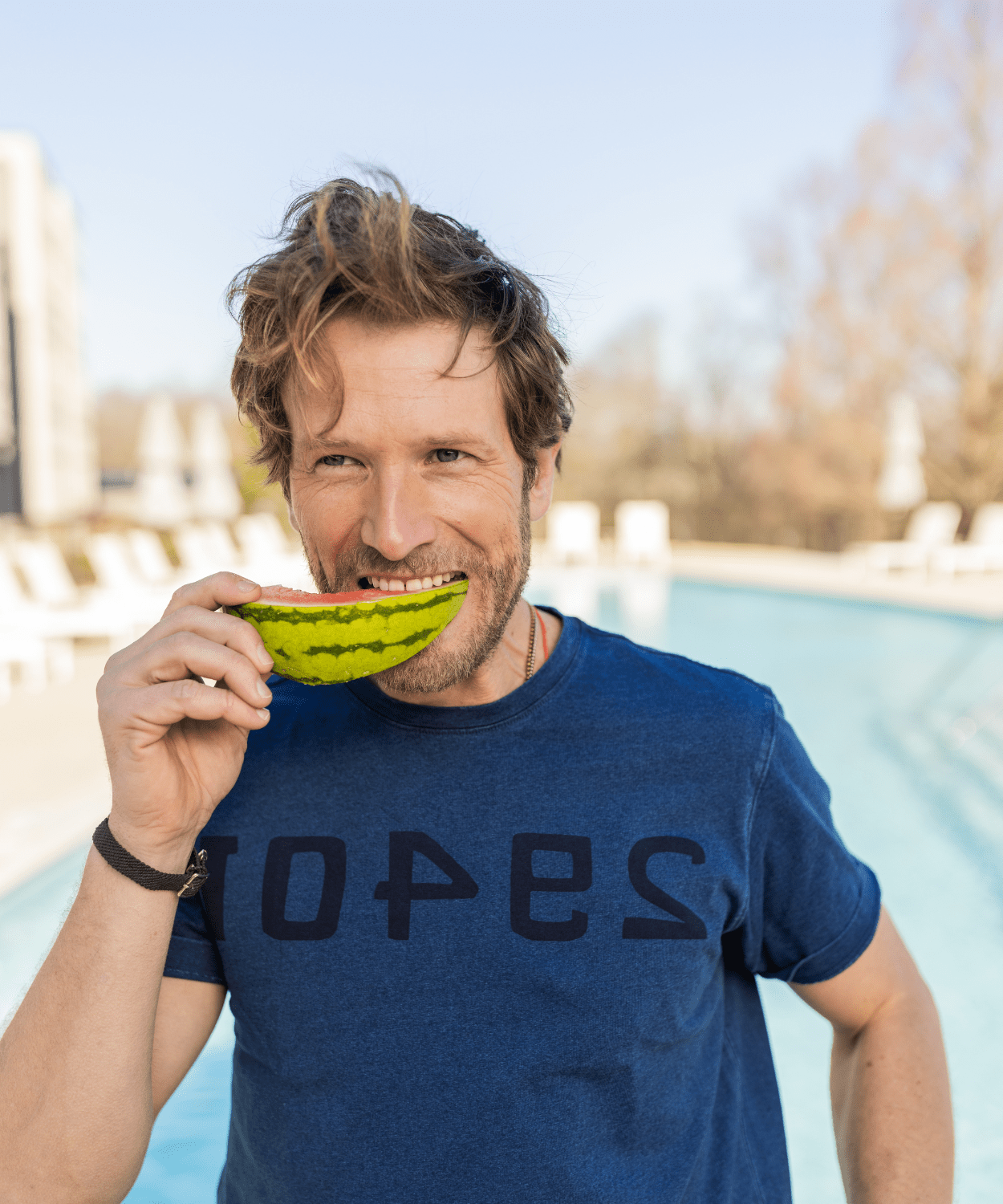 man eating a melon in an oobe brand graphic tee