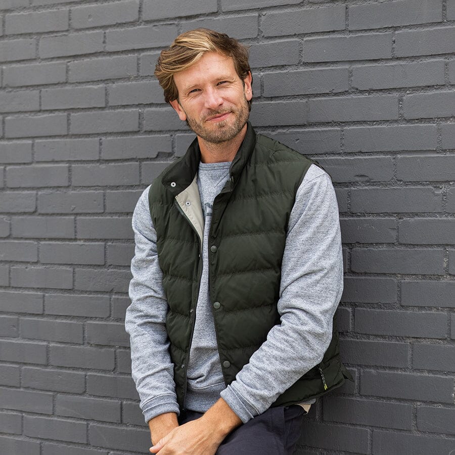 man leaning against a wall in a vest by oobe brand