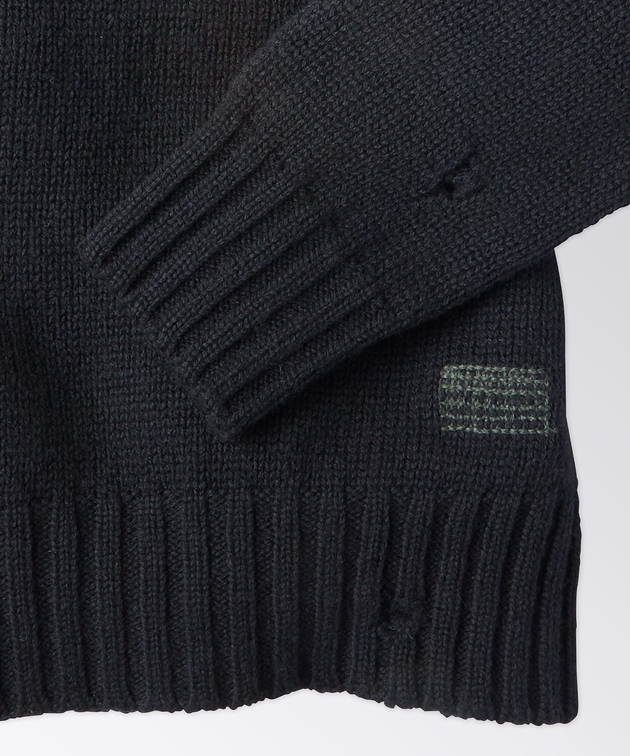 sleeve detail of a black sweater